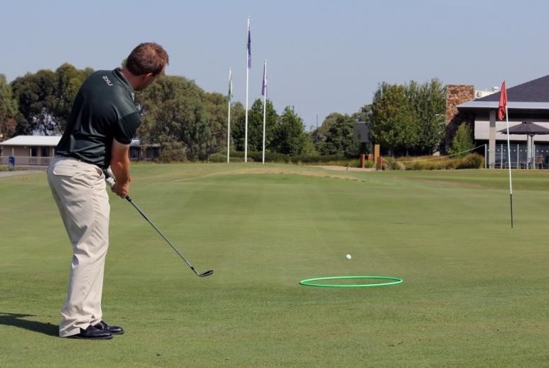 Golfer practicing chipping to a landing spot on the green